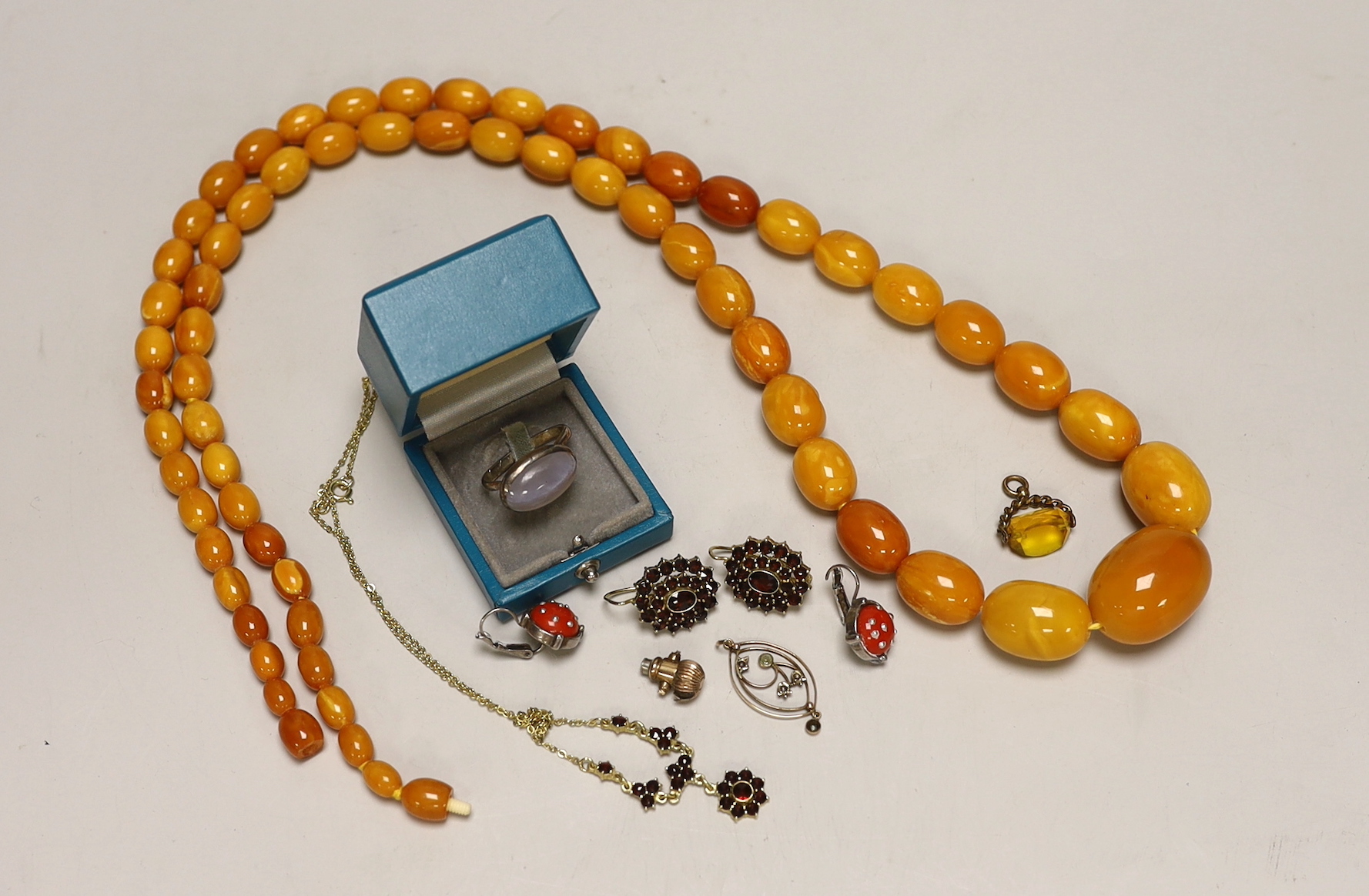 A single strand graduated oval amber bead necklace, 98cm, gross weight 94 grams and other sundry jewellery.